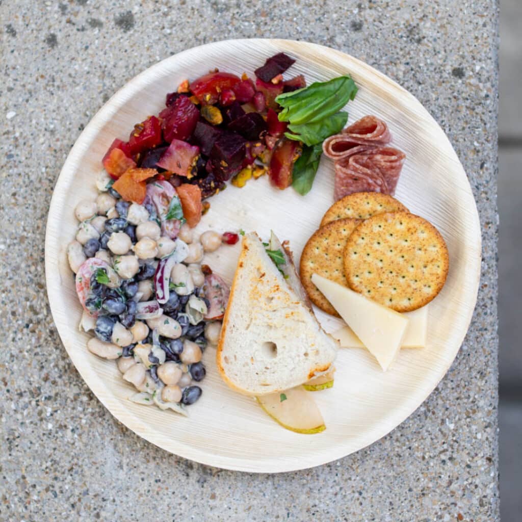 A plate of beans, bread, and beets on a plate from Frascati Market